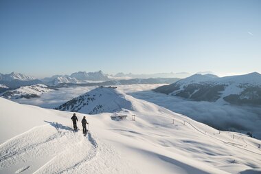 2 Skifahrer auf einem verschneiten Berg | © saalbach.com, Moritz Ablinger