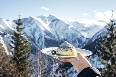 Germknoedel mit verschneiten Bergen im Hintergrund | © Zell am See-Kaprun Tourismus